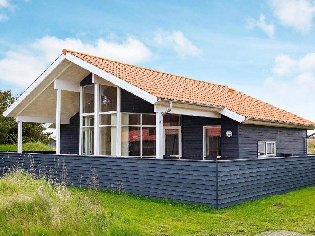 a blue house with an orange roof at Three-Bedroom Holiday home in Ulfborg 23 in Fjand Gårde