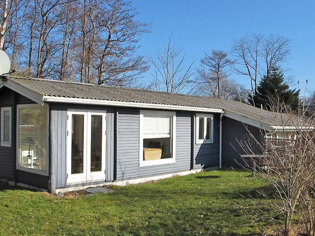 een klein huis met een raam en een tuin bij 4 person holiday home in Stege in Pollerup Kullegård