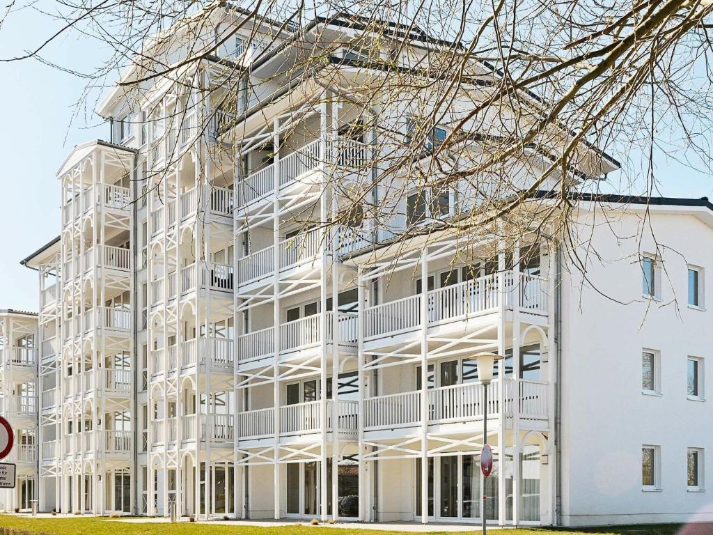 a white apartment building with white balconies at 6 person holiday home in Gro enbrode in Großenbrode