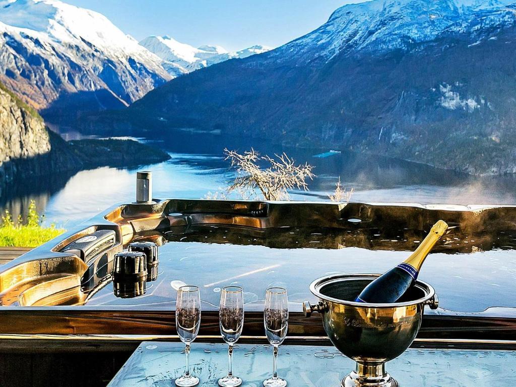 a table with wine glasses and a bowl with a bottle at 8 person holiday home in Valldal in Valldal