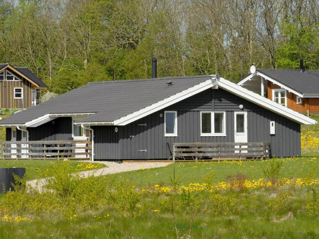 ein schwarzes Haus mit weißem Dach in der Unterkunft Three-Bedroom Holiday home in Sydals 9 in Vibøge