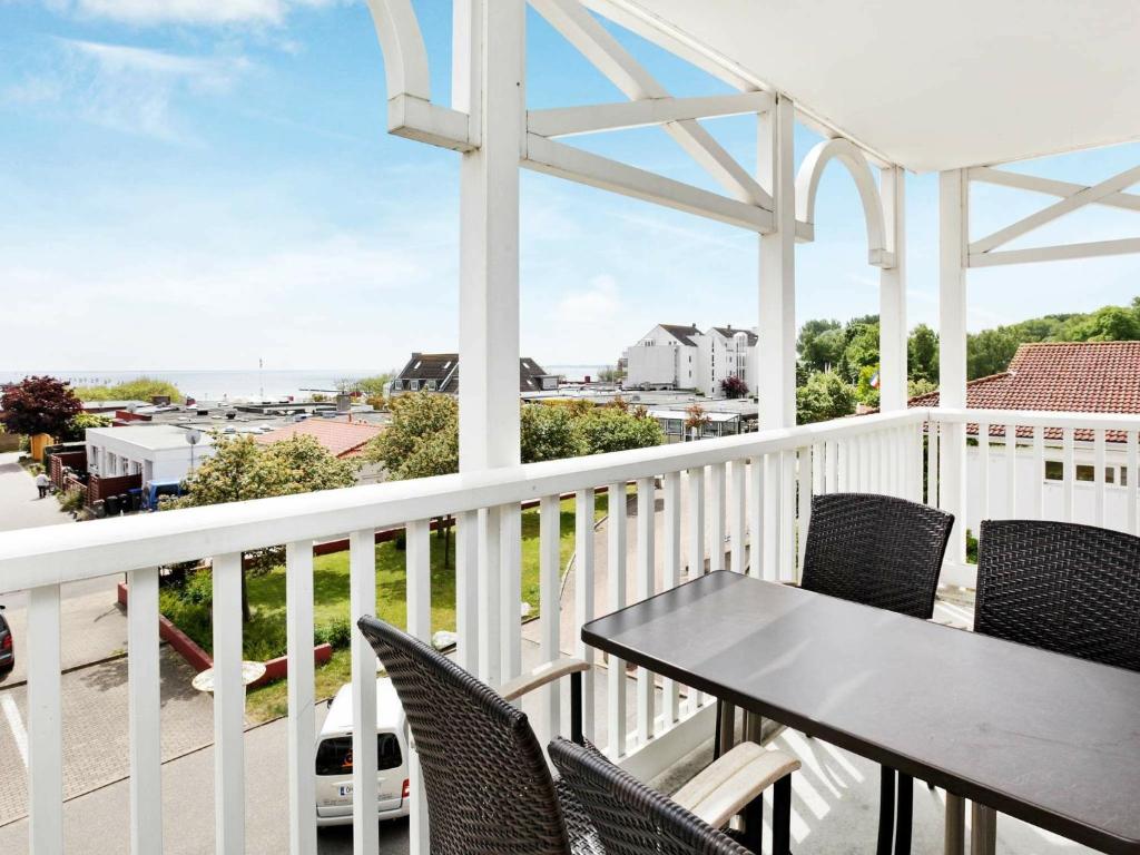 einen Balkon mit einem Tisch, Stühlen und Meerblick in der Unterkunft Two-Bedroom Holiday home in Großenbrode 18 in Großenbrode