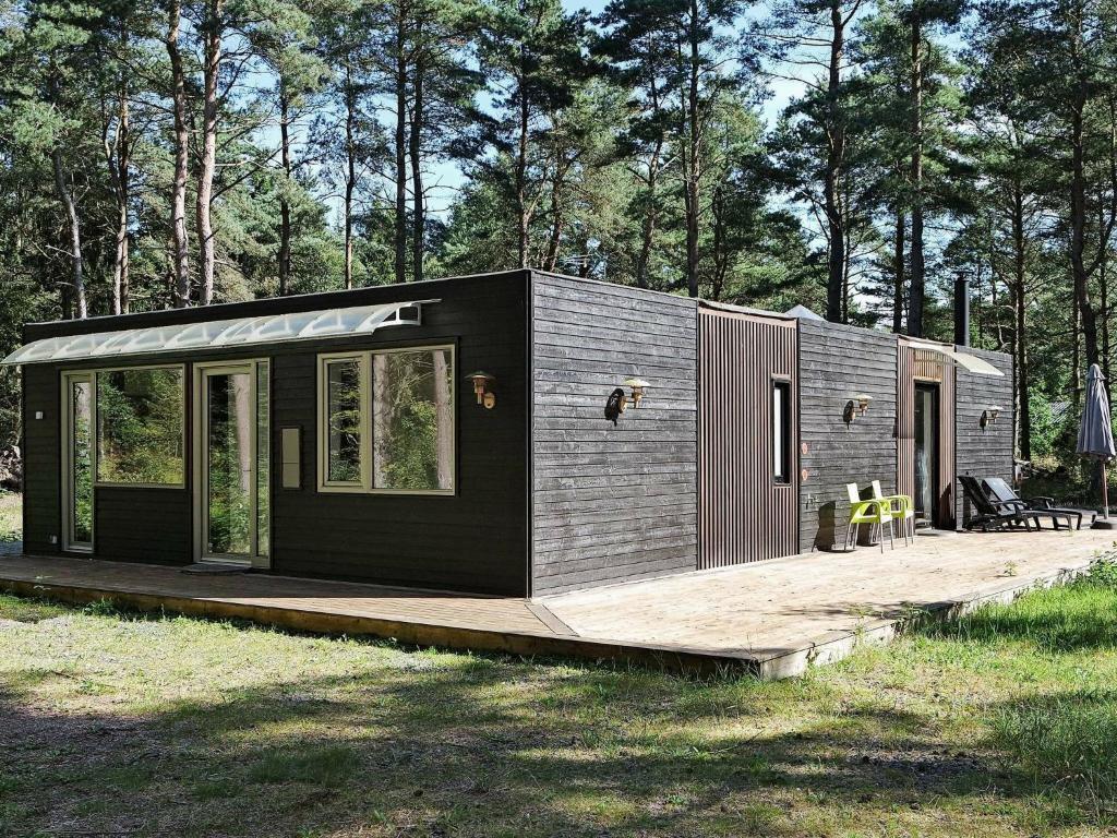 una pequeña casa negra y gris en un campo en 6 person holiday home in Hadsund, en Odde