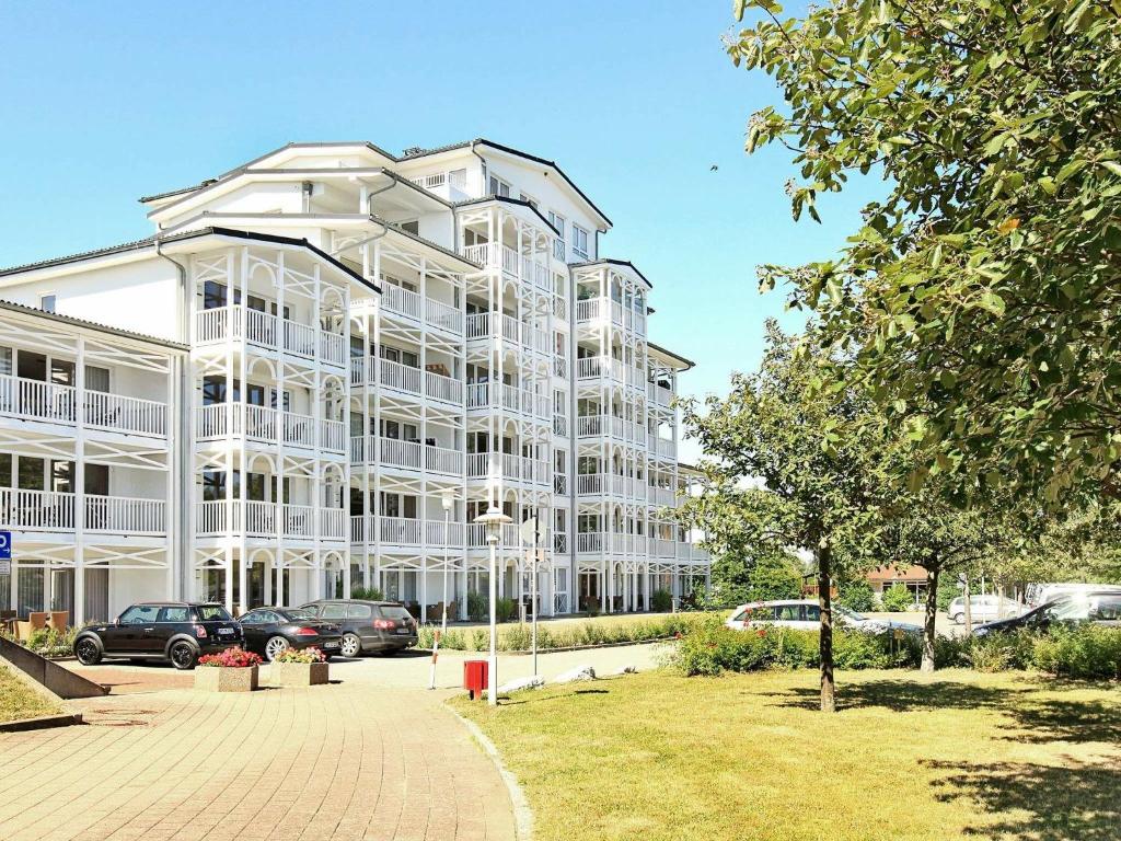 a large white building with cars parked in a parking lot at 4 person holiday home in Gro enbrode in Großenbrode