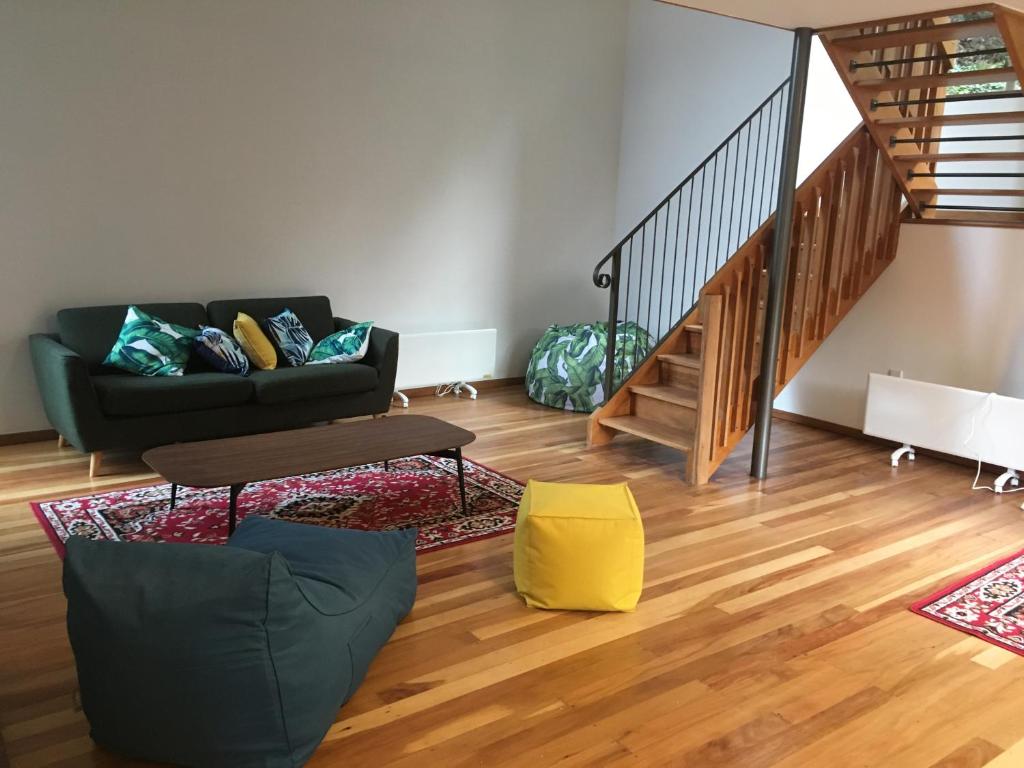 een woonkamer met een bank en een trap bij Mountain Creek Vacation in Queenstown
