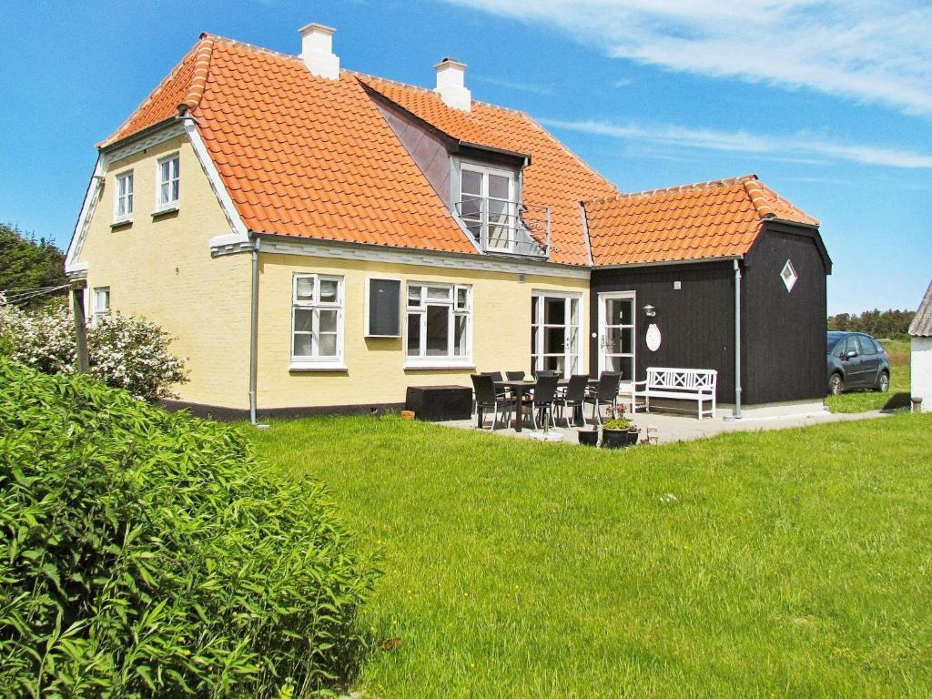 a yellow house with an orange roof on a yard at 6 person holiday home in Skagen in Hulsig