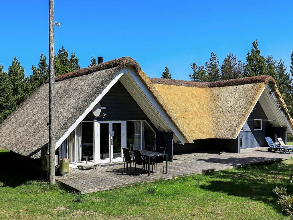 Casa con techo de paja y terraza de madera en 8 person holiday home in Bl vand en Blåvand