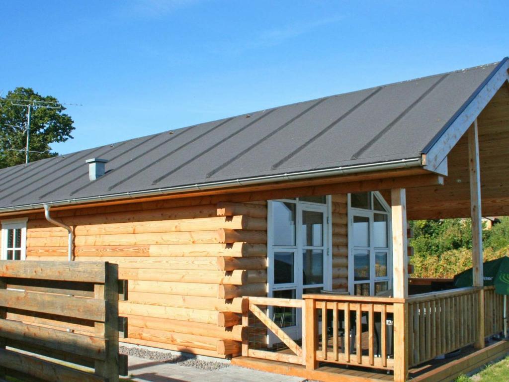 a log cabin with a metal roof and a porch at 6 person holiday home in Allinge in Allinge