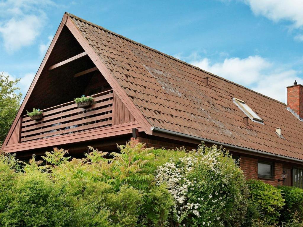 スベンボーにある2 person holiday home in Svendborgの鉢植えの植物が2本ある葺き屋根の家