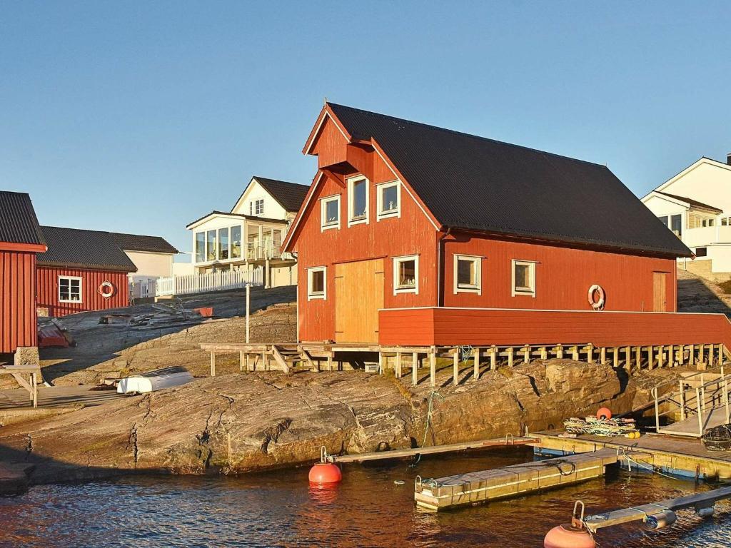 una gran casa roja junto a un cuerpo de agua en Holiday home bud, en Bud