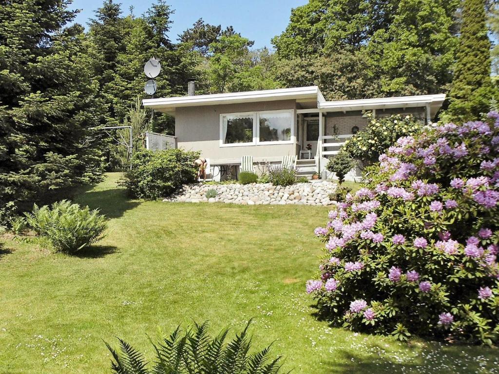 a small white house with a yard with flowers at 6 person holiday home in Nyk bing Sj in Højby