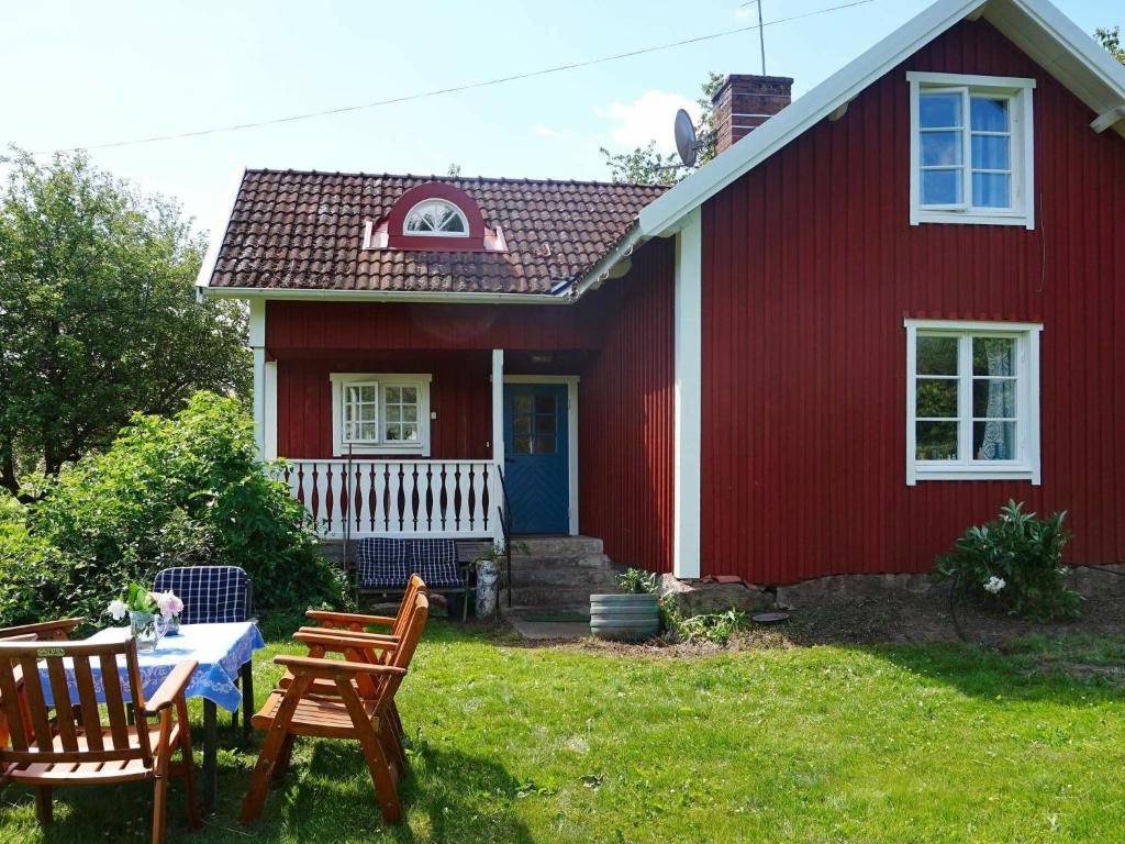 una casa roja con una mesa y sillas frente a ella en 6 person holiday home in INGATORP, en Ingatorp