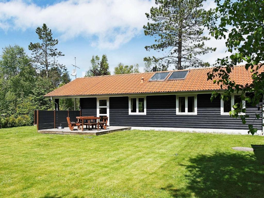 una casa negra con una mesa de picnic en el patio en 6 person holiday home in Hadsund, en Helberskov