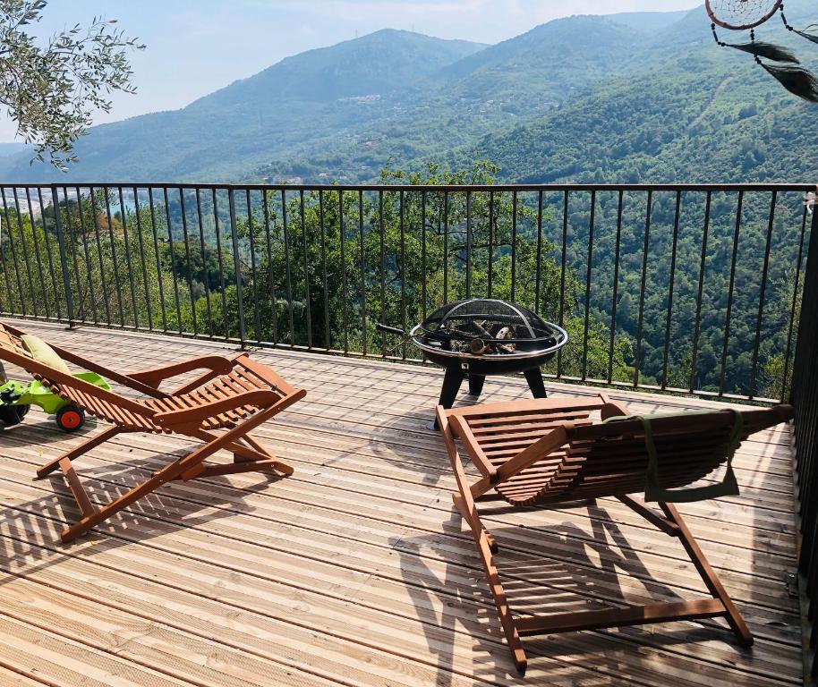 two chairs and a table on a wooden deck with mountains at Cabane de L Esteron in Gilette