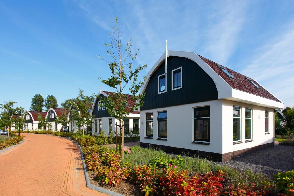 a house with a black and white roof at Europarcs Koningshof in Schoorl