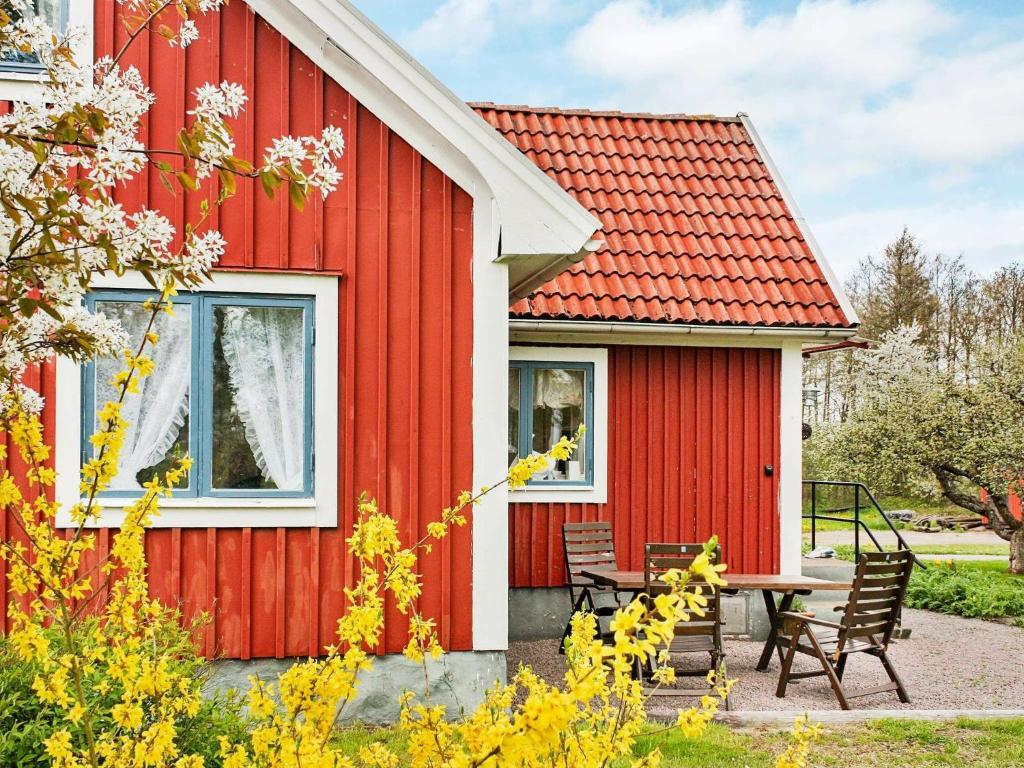una casa roja con una mesa de picnic delante de ella en 4 person holiday home in S DER KRA, en Söderåkra