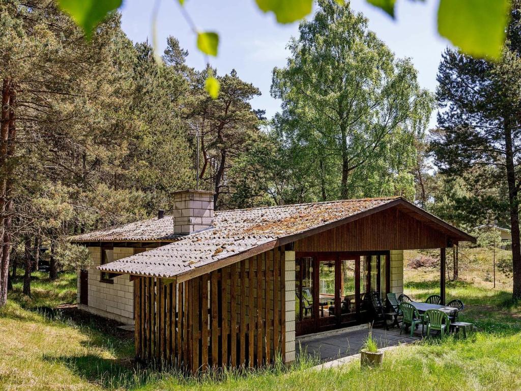 eine kleine Hütte mit Kamin und Terrasse in der Unterkunft 4 person holiday home in Nex in Tjørneby