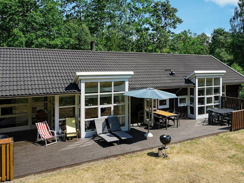 Casa con terraza con sillas y sombrilla en 8 person holiday home in Hasle, en Hasle