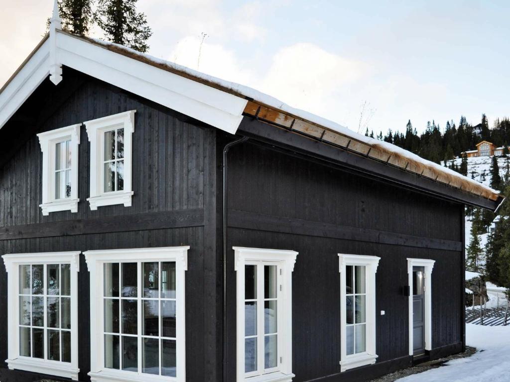 a black house with white windows and snow at 5 person holiday home in F vang in Favang