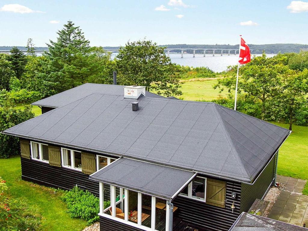 a black house with a gray roof and a flag at Holiday home Roslev III in Roslev