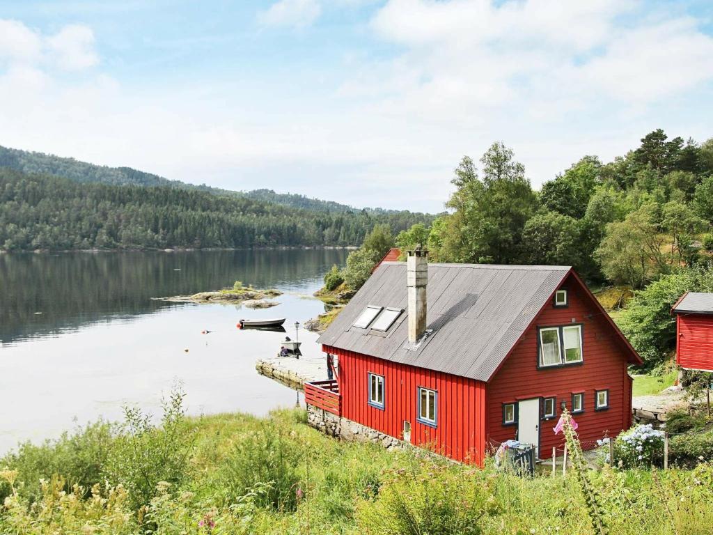 Holiday Home Litlevågen في Bysheim: منزل احمر على شاطئ البحيرة