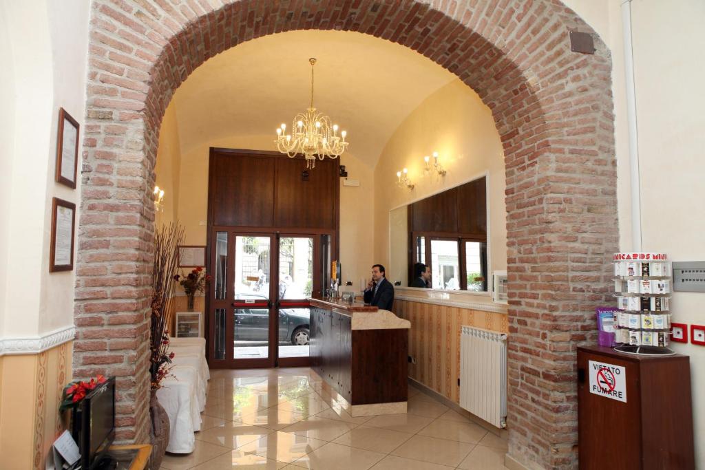 a man is standing at a counter in a restaurant at Hotel Hollywood in Rome