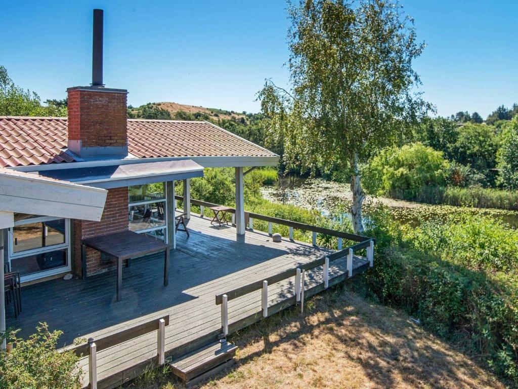 Ørbyにある6 person holiday home in Knebelの木の横に木のデッキがある家