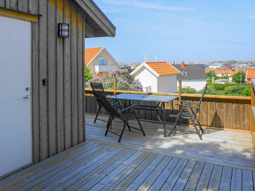 a patio with a table and chairs on a deck at 3 person holiday home in R nn ng in Rönnäng