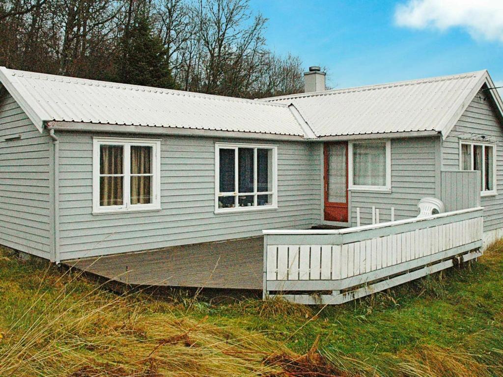 una piccola casa bianca con un ampio portico di One-Bedroom Holiday home in Frei a Frei