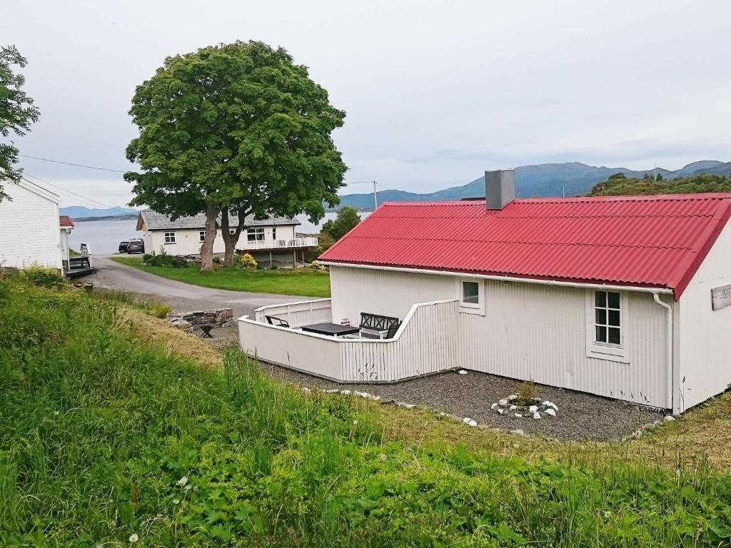 una pequeña casa blanca con techo rojo y carretera en Holiday Home Årsbogvegen, en Vevang