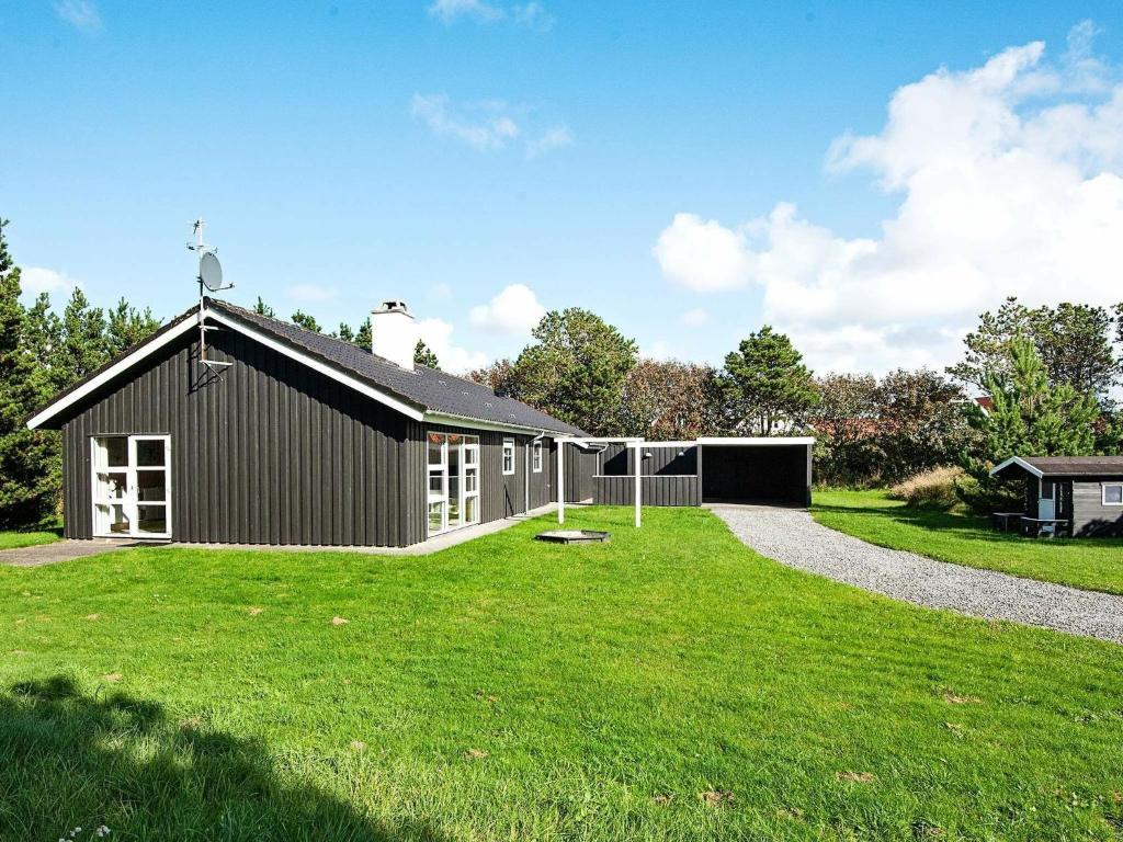 ブラーバンドにあるHoliday Home Kallesensvejの前に緑の芝生がある黒い家