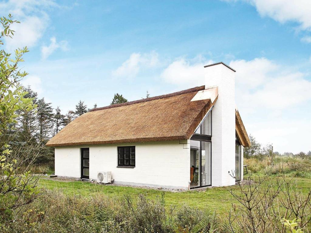 ein weißes Haus mit einem braunen Dach auf einem Feld in der Unterkunft 7 person holiday home in Fjerritslev in Torup Strand