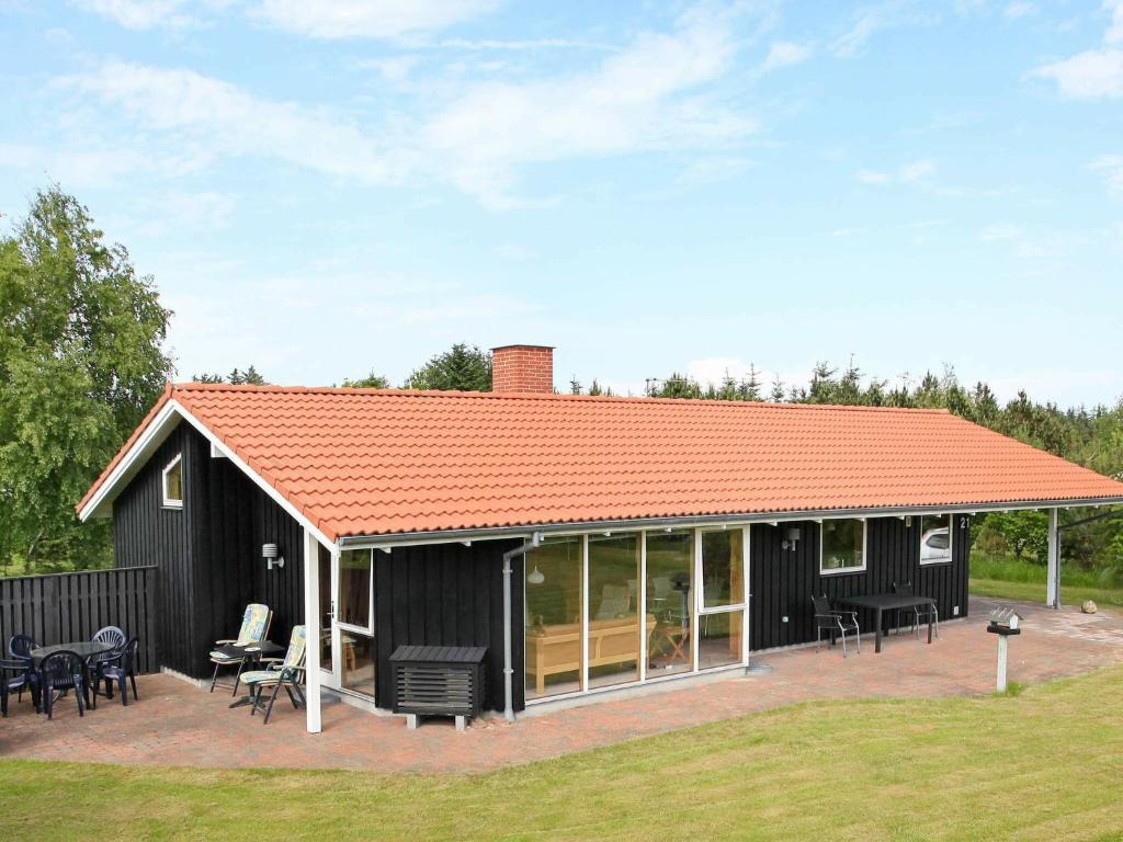 a black house with an orange roof at 6 person holiday home in Fjerritslev in Torup Strand