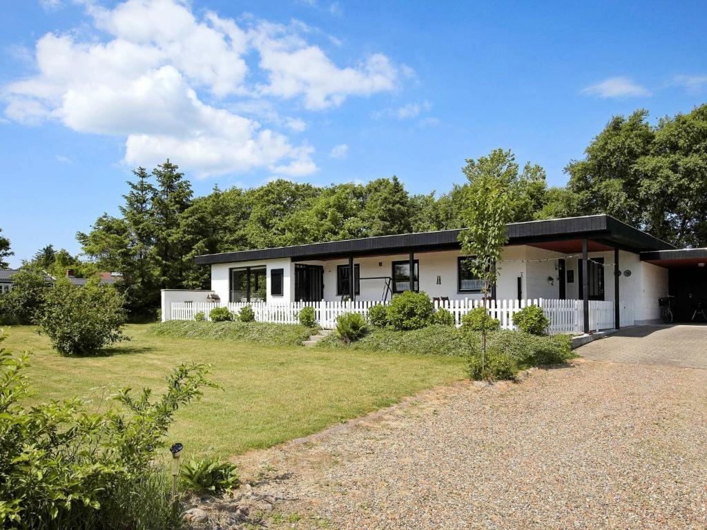 a white house with a black roof and a yard at 8 person holiday home in Struer in Humlum