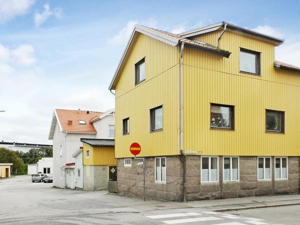 un edificio amarillo con una señal roja. en Holiday Home Västra IV, en Lysekil