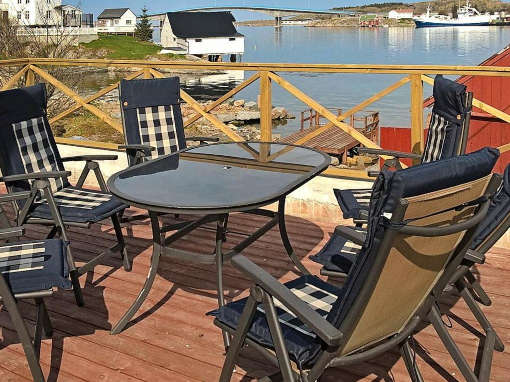 una mesa y sillas en una terraza con vistas al agua en Holiday Home Reksundveien en Henda