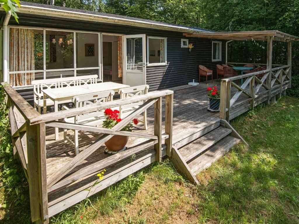 eine Holzterrasse mit einem Tisch und Stühlen auf einem Haus in der Unterkunft 4 person holiday home in Silkeborg in Silkeborg