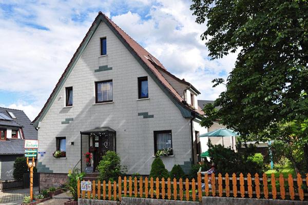 une maison blanche avec une clôture devant elle dans l'établissement Pension Haus Barbara Oberhof, à Oberhof