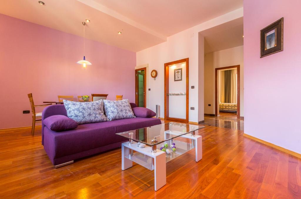 a living room with a purple couch and a table at Pula Citybreak in Pula