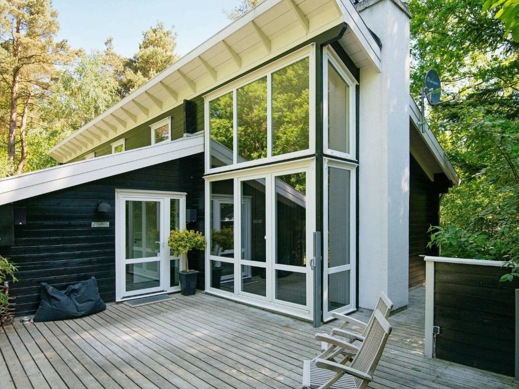 una casa con una gran puerta de cristal en una cubierta en Holiday home Rønde IX, en Rønde