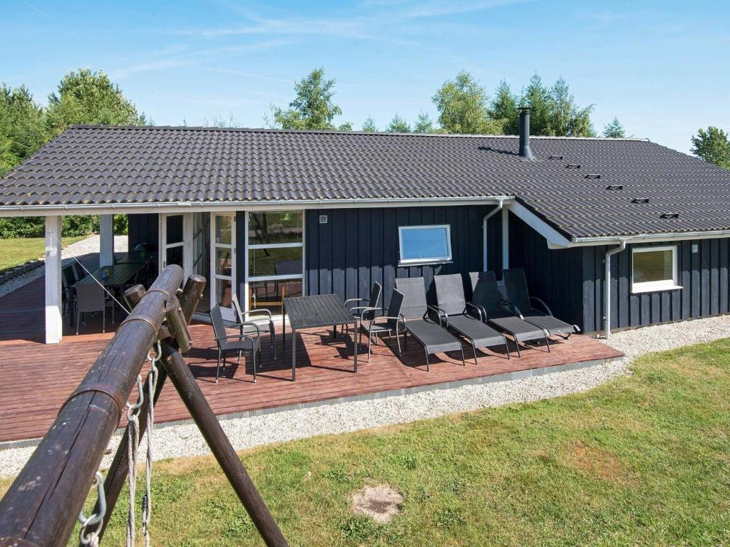 a house with a deck with chairs and a table at Holiday home Glesborg XXXIII in Glesborg