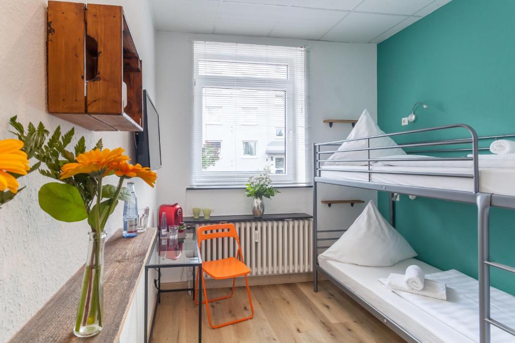 ハノーファーにあるCity-Apartment Hannoverの二段ベッド1組、デスクが備わる小さな客室です。