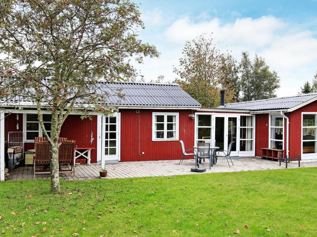 a red house with a patio and a yard at 6 person holiday home in Store Fuglede in Store Fuglede
