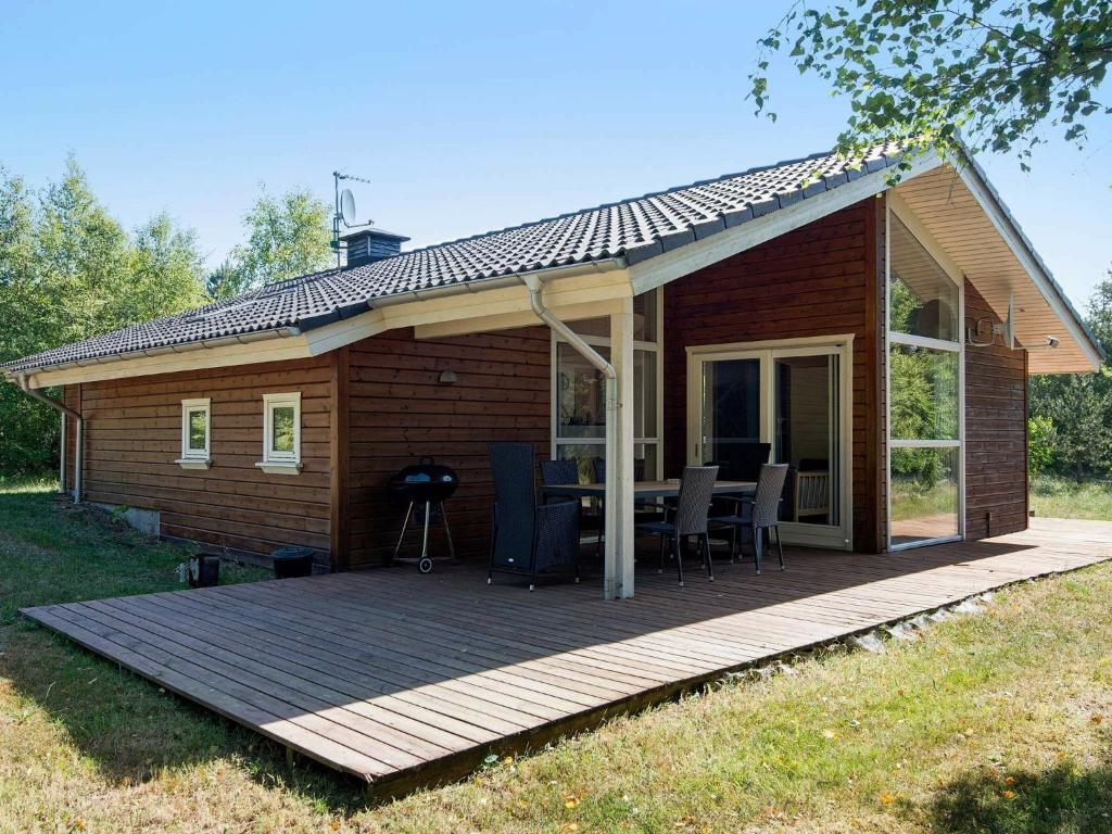 a cabin with a deck and a grill at 6 person holiday home in Ringk bing in Ringkøbing