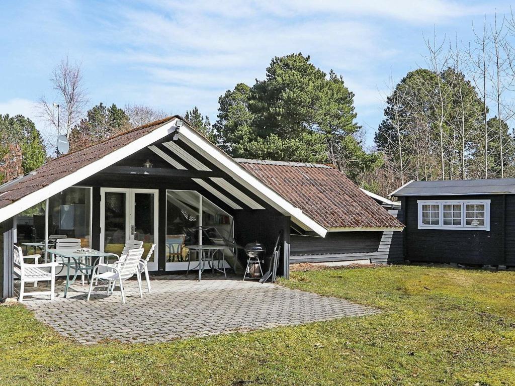 a house with a patio with a table and chairs at 6 person holiday home in R dby in Rødby