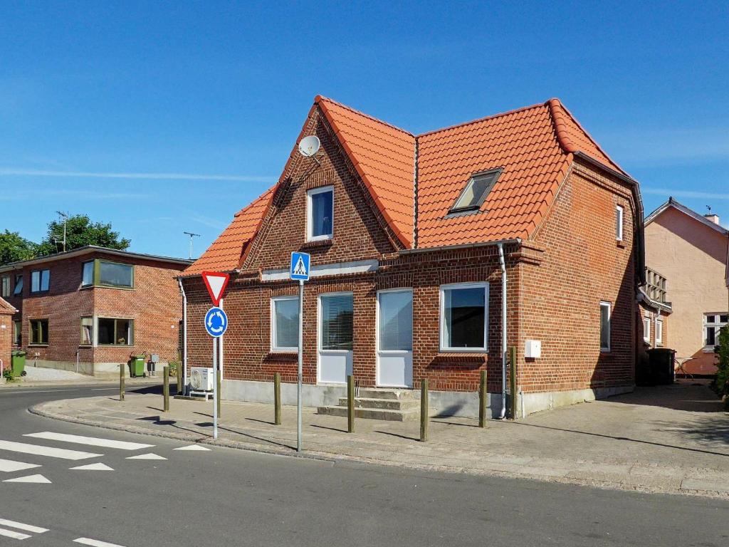 a brick house with an orange roof on a street at Apartment Lemvig II in Lemvig
