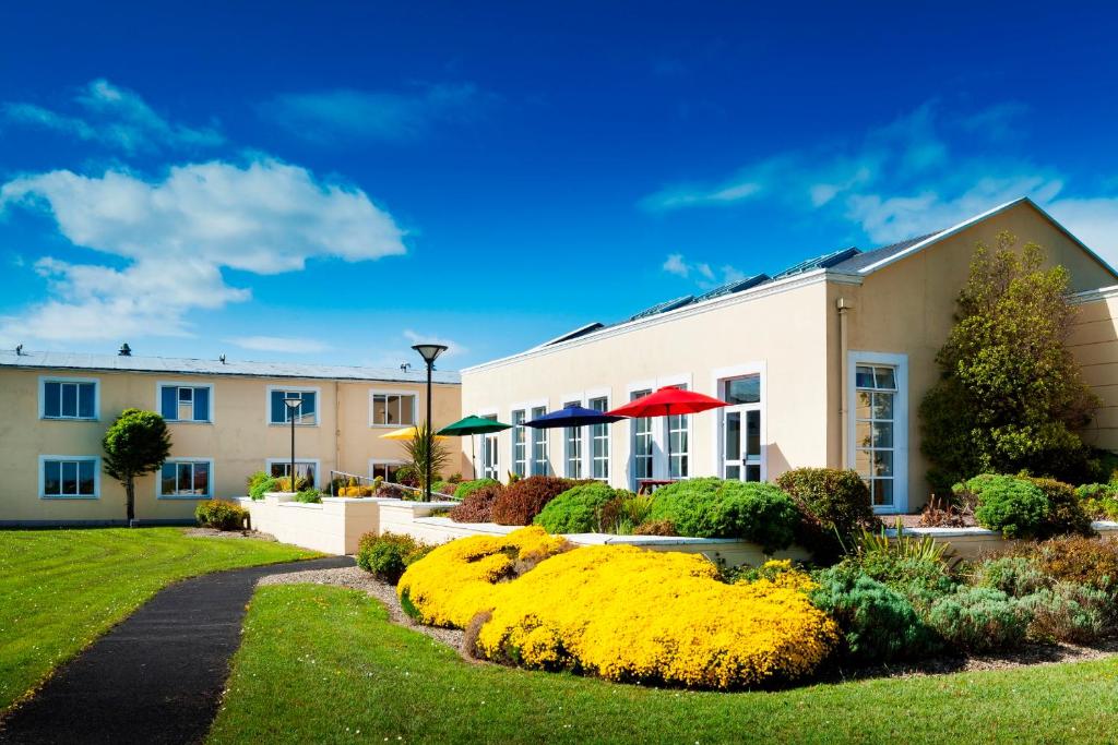a building with yellow flowers in a yard at Park Inn by Radisson Shannon Airport in Shannon
