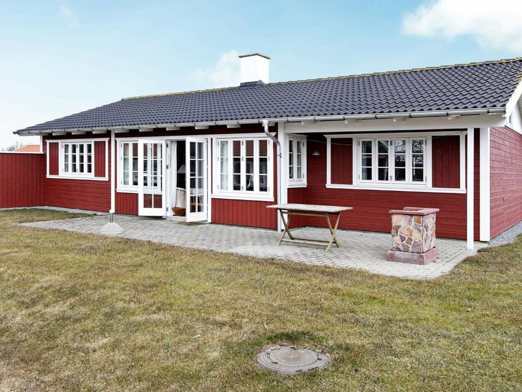 een rood huis met een picknicktafel ervoor bij 8 person holiday home in Aabenraa in Danland Løjt