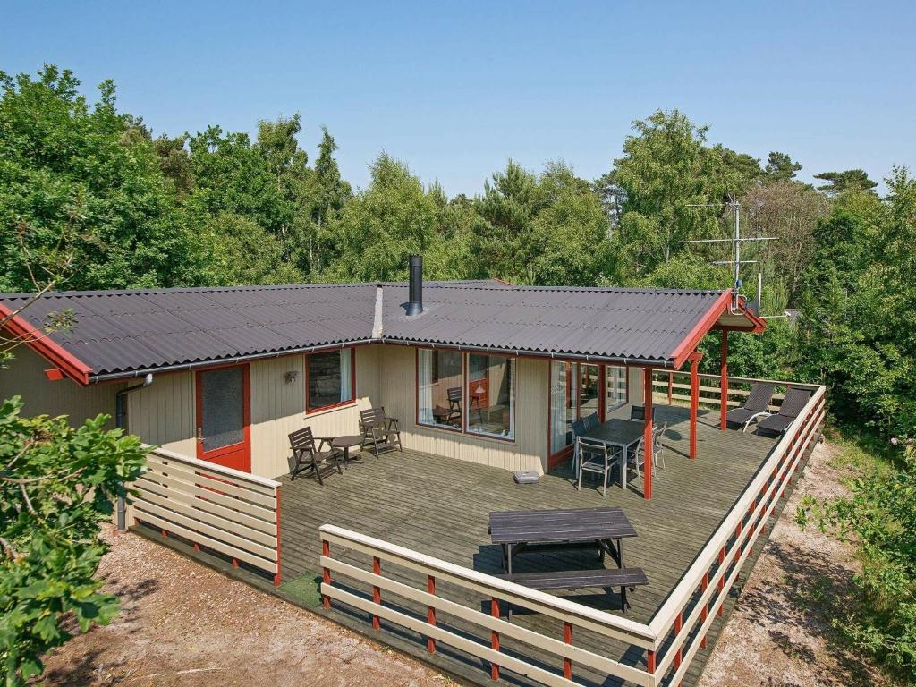 een huis met een terras met een zonnedak bij 6 person holiday home in Aakirkeby in Vester Sømarken