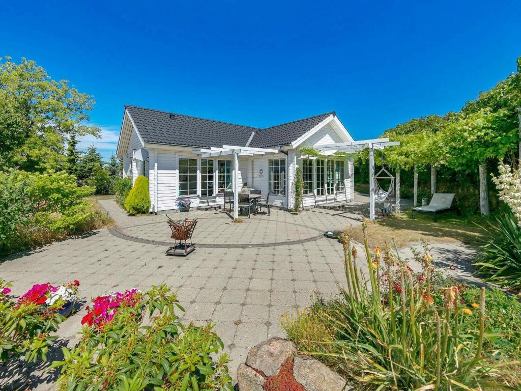 une maison avec une terrasse et des fleurs dans la cour dans l'établissement Holiday home Millinge II, à Millinge